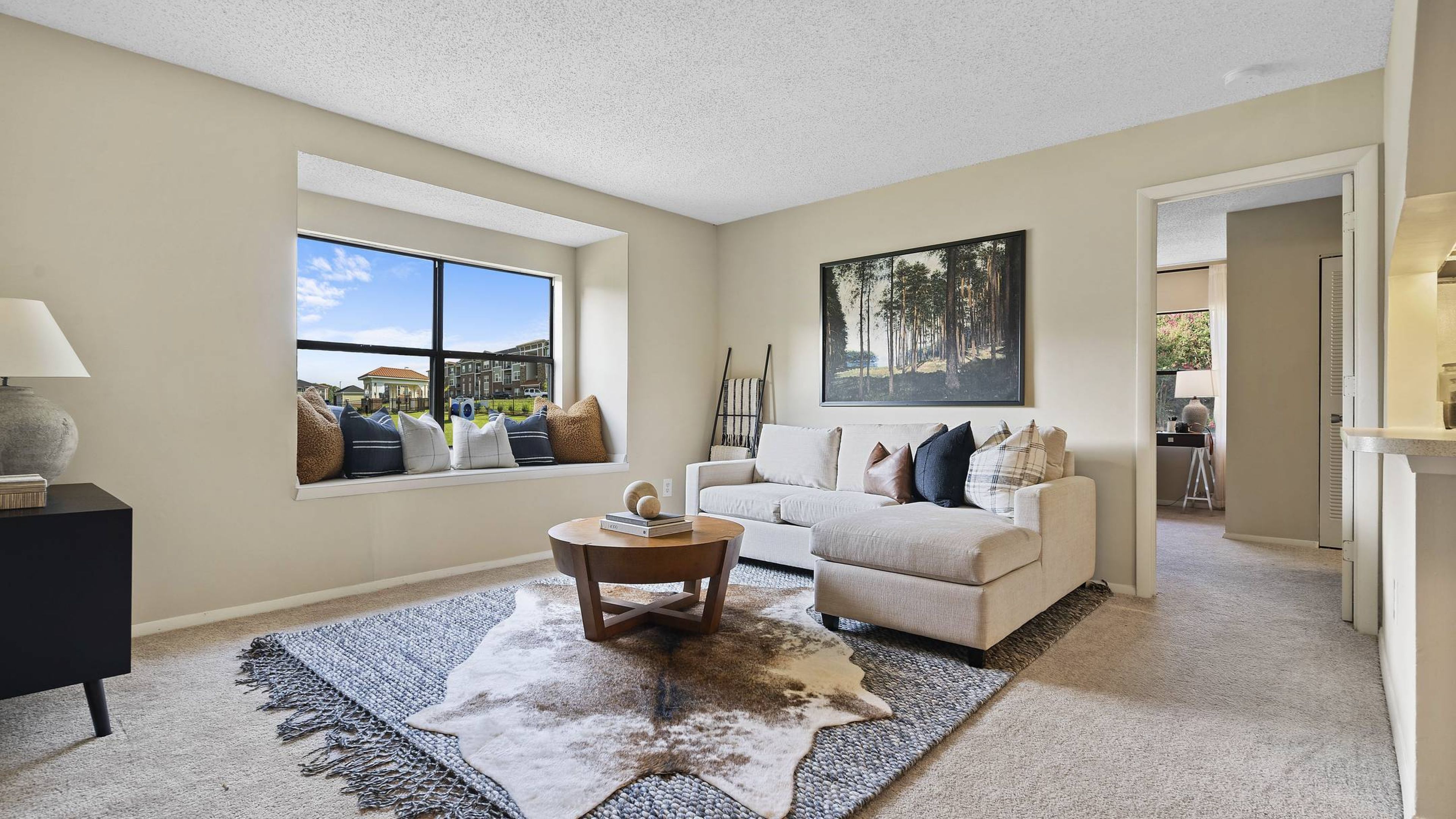 A cozy living room with a comfortable couch, a stylish coffee table, and a large window offering natural light at Hawthorne at Southside
